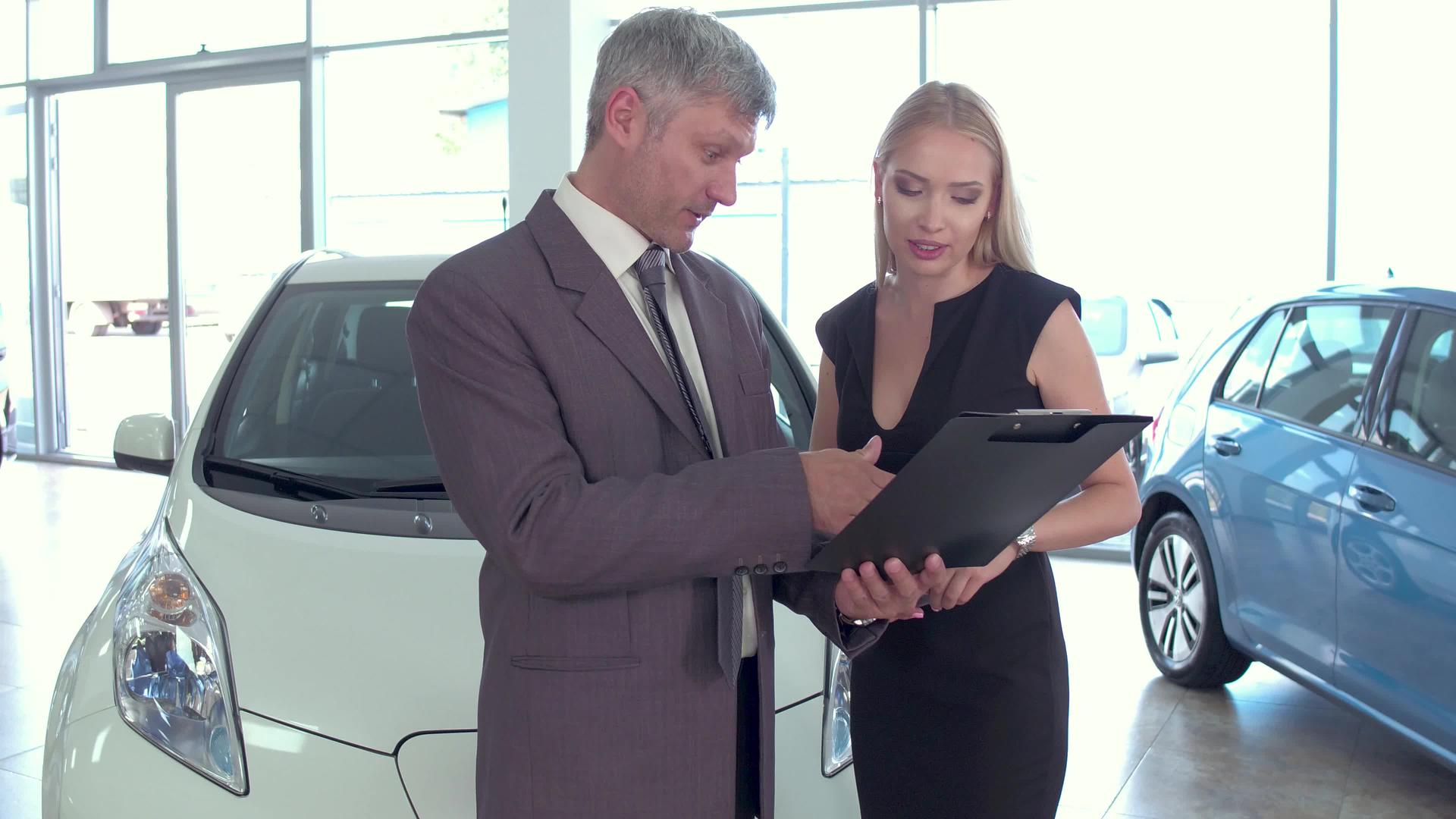 汽车经销商与女性客户交谈视频的预览图
