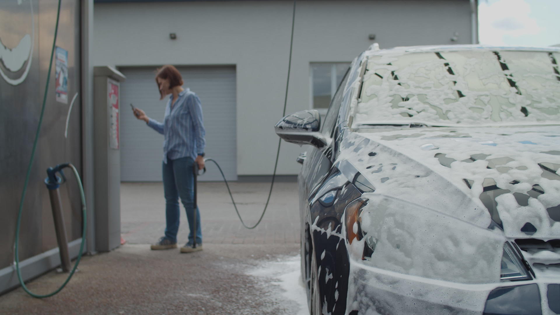 30多岁的年轻女性使用移动应用程序支付自助洗车费用视频的预览图