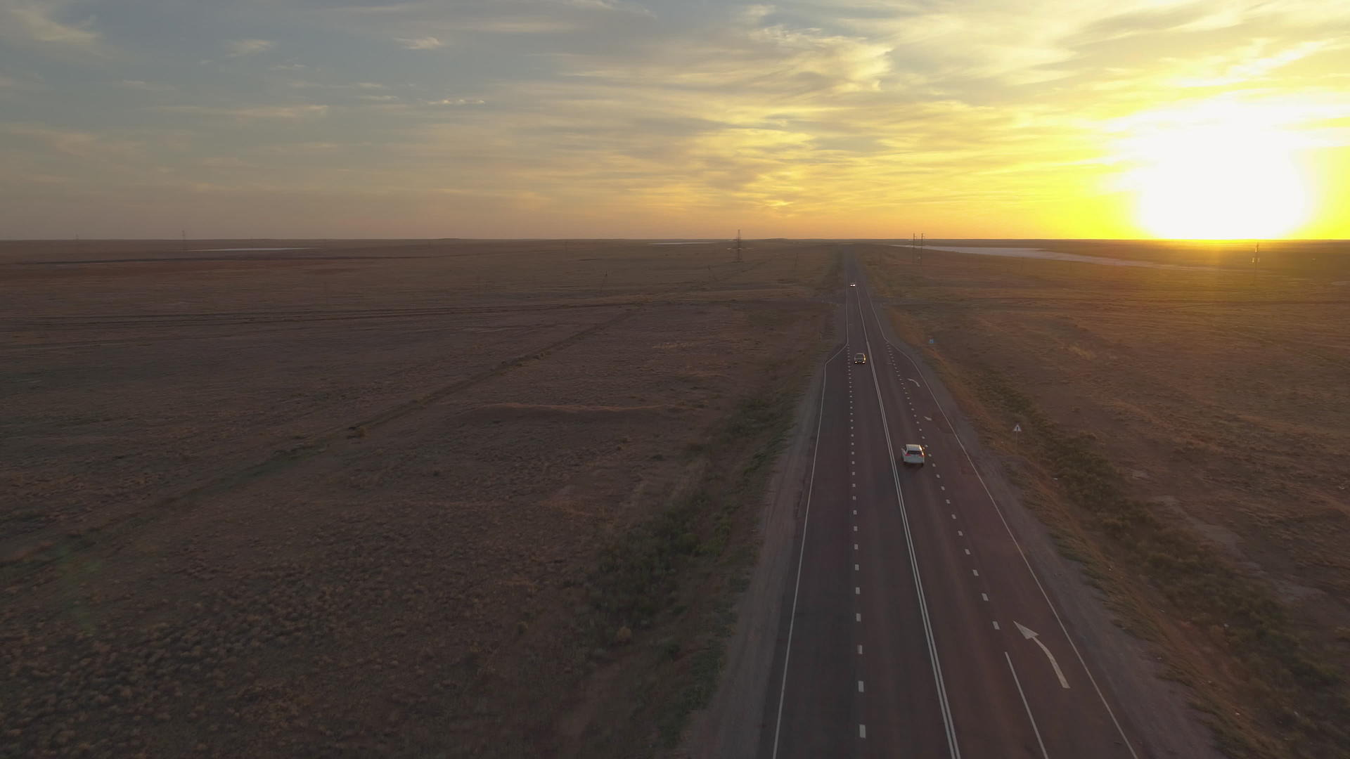 日落时观察草原高速公路上的汽车视频的预览图