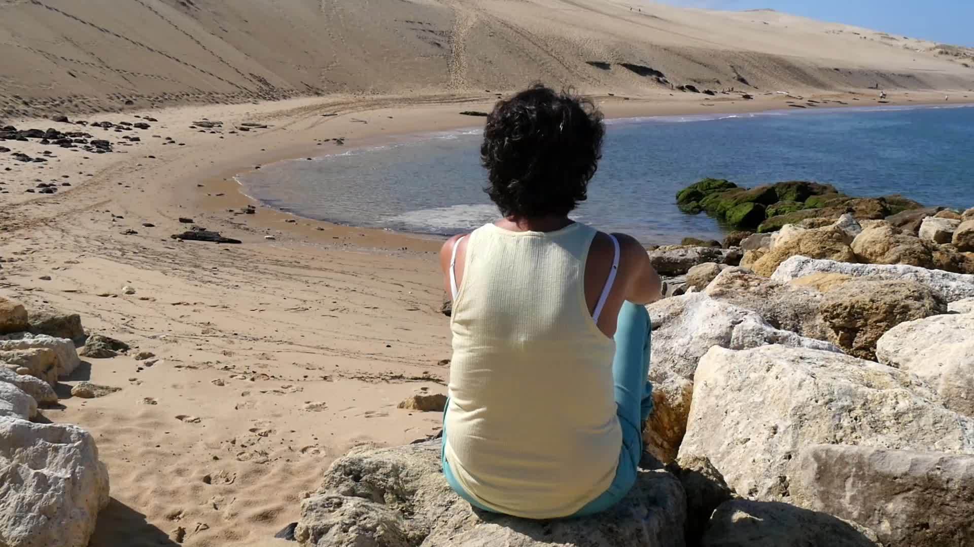 女人看着阴阳附近的大海视频的预览图