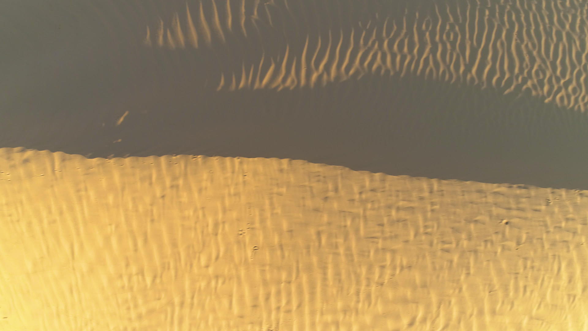 无人驾驶飞机在沙漠沙丘上向左飞行垂直直射视频的预览图