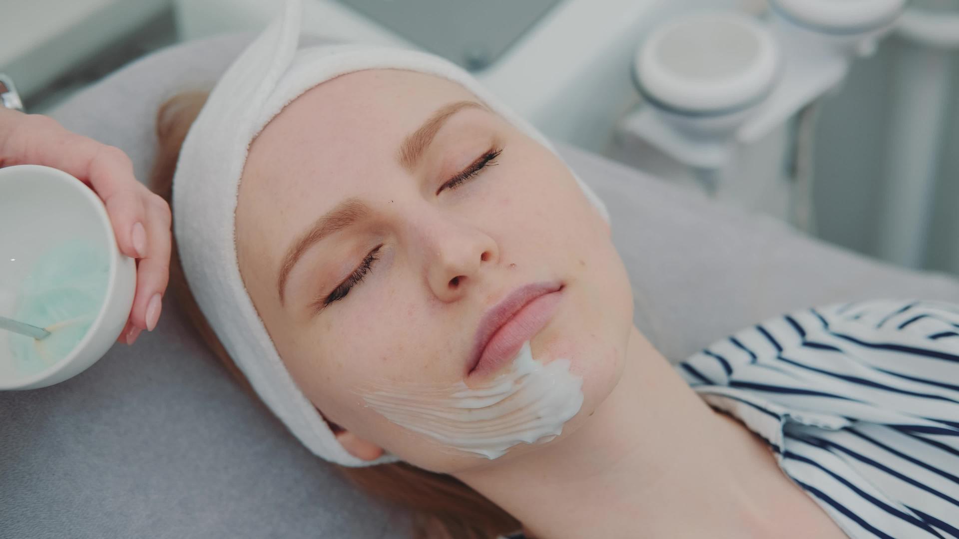 在美容院年轻女性的脸上涂上奶油面具视频的预览图