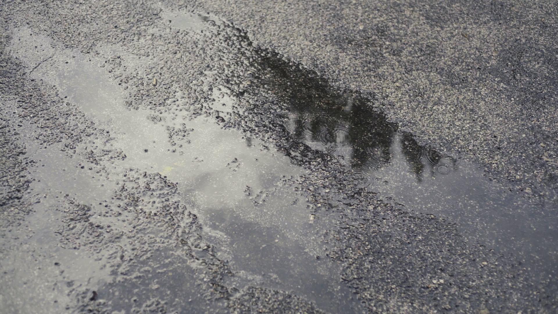 沥青上的泥坑加上2滴雨滴视频的预览图
