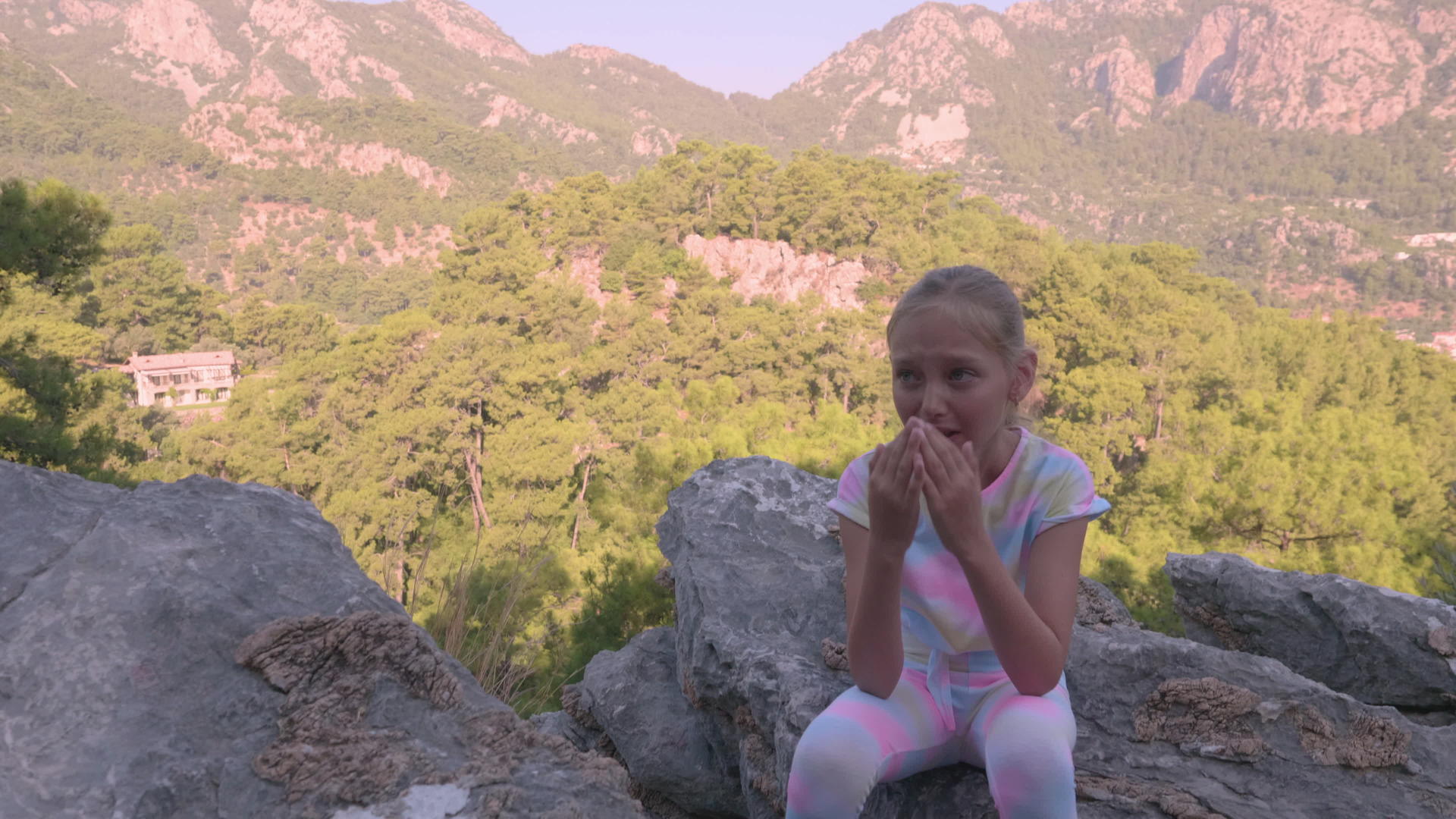 坐在岩石上在山上哭泣视频的预览图