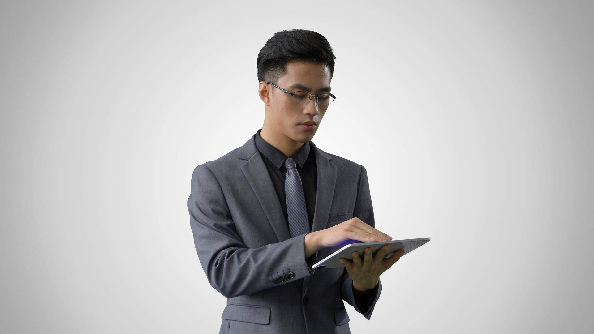 4k灰底穿西装戴眼镜的商务男士使用平板电脑上网视频的预览图