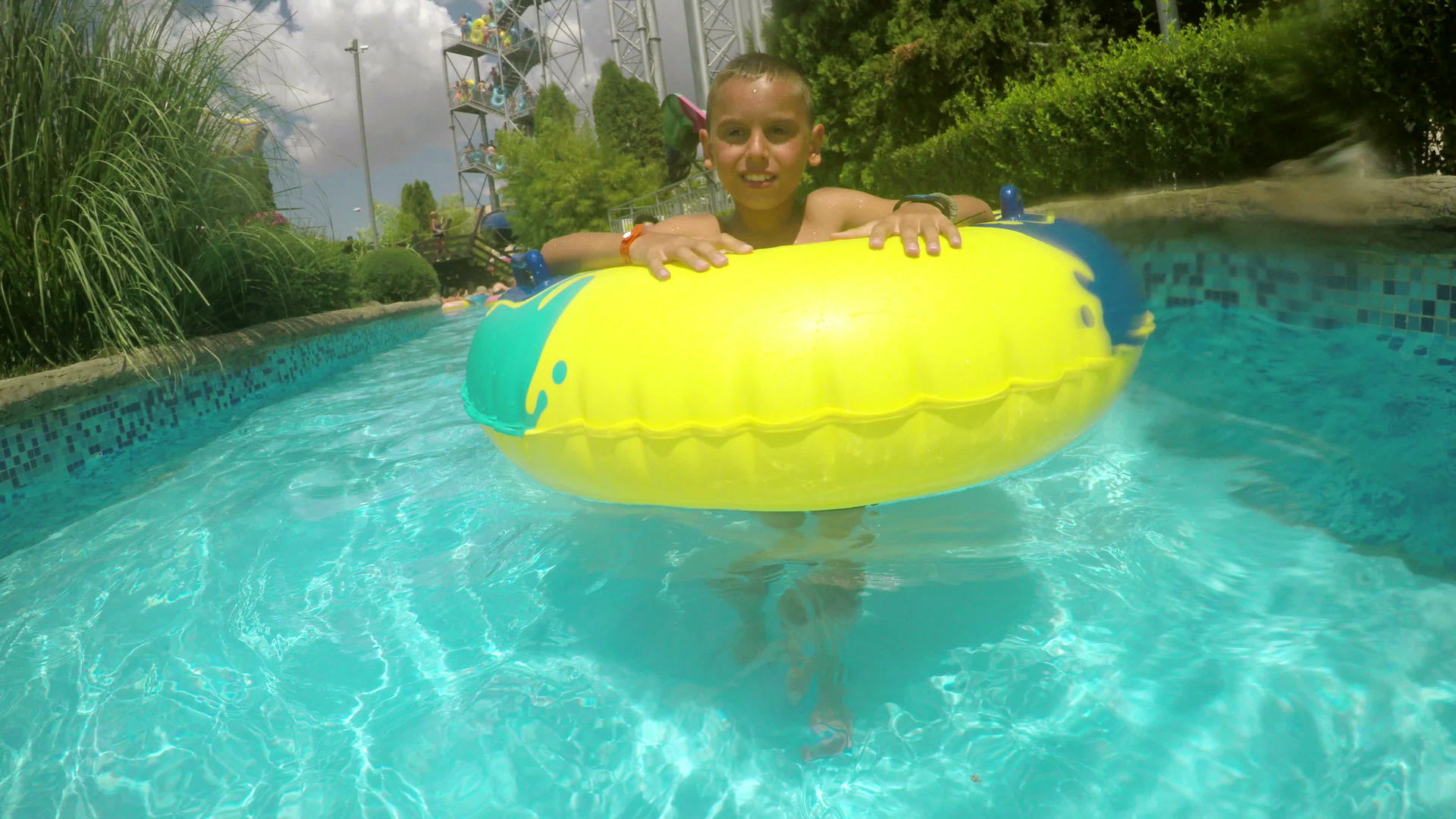 快乐的男孩享受水上公园橡胶游泳在懒洋洋的河里游泳视频的预览图
