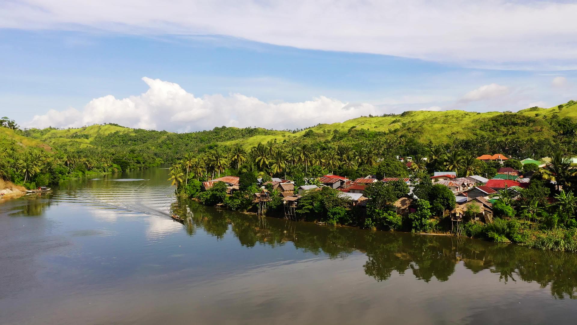 在阳光明媚的天气下热带风景河边的村庄Philipppines视频的预览图