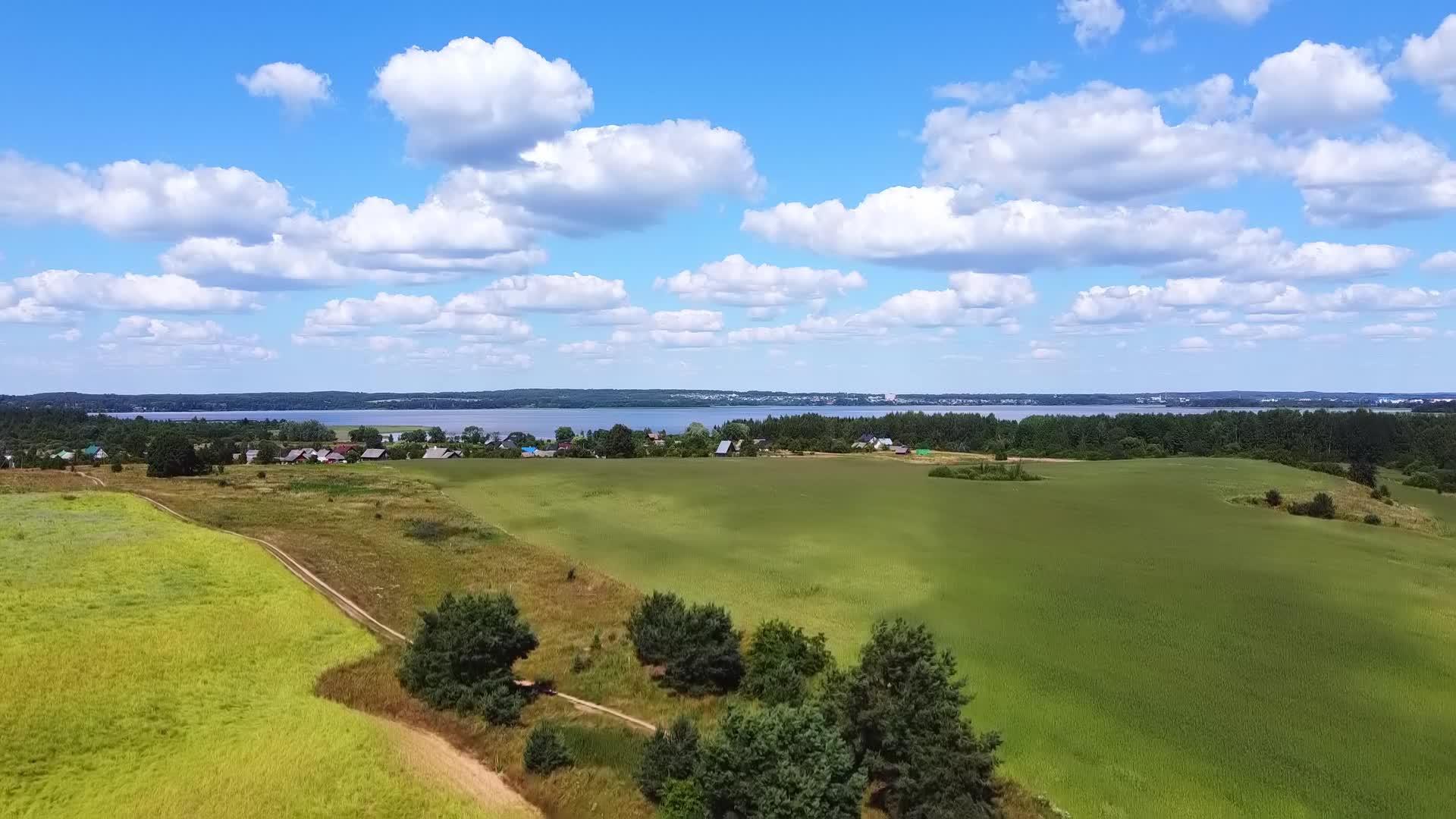 无人机从绿草中起飞观察蓝湖和白云的场景视频的预览图