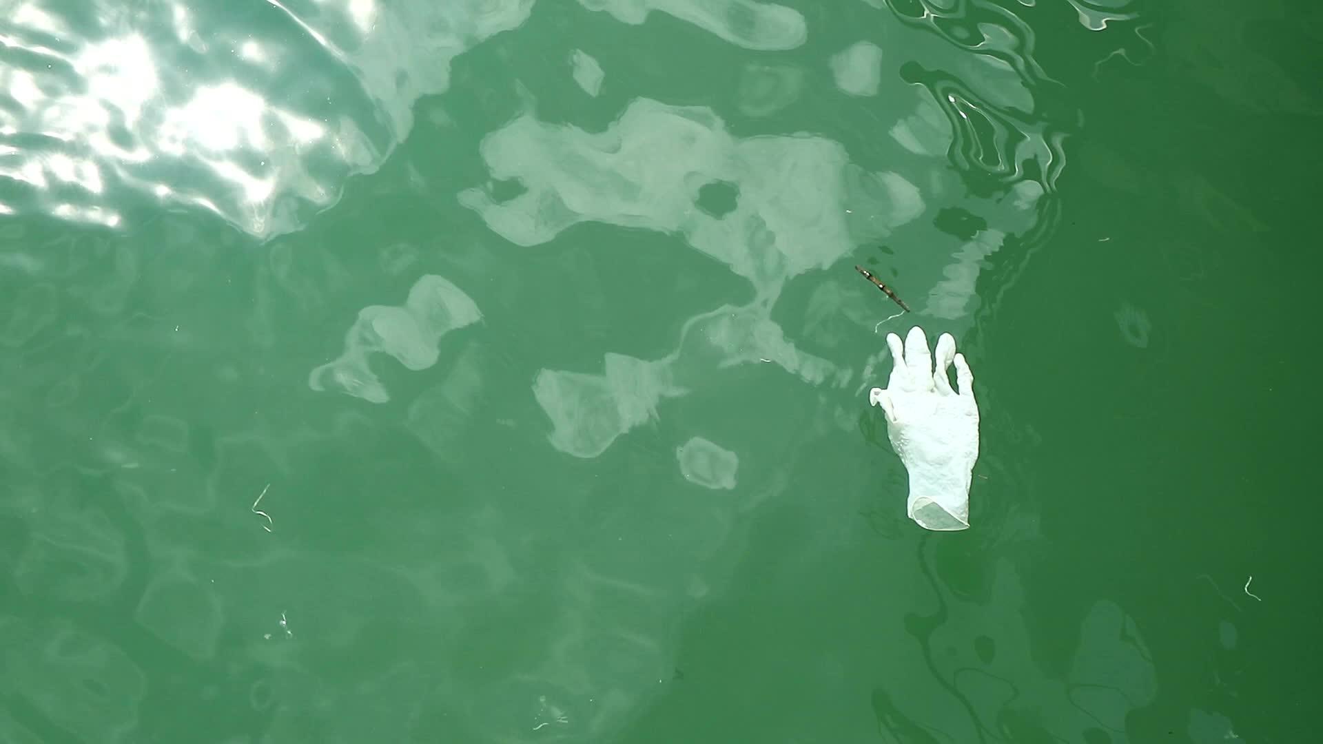 橡胶手套漂浮在海面水面上视频的预览图