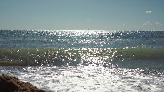 船停泊在海面的海平线上从海滩上可以看到水闪闪发光视频的预览图
