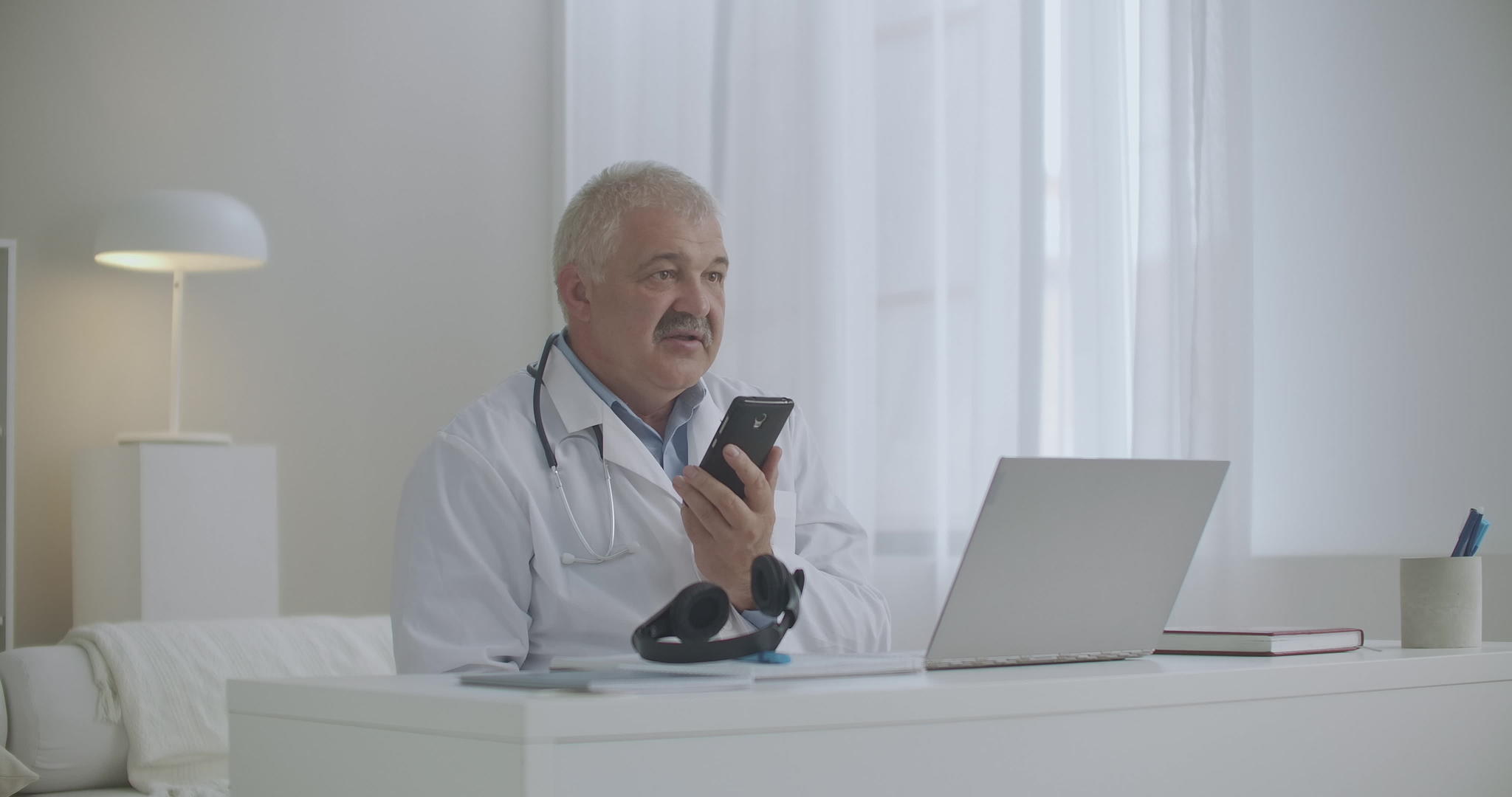 经验丰富的治疗师正在用手机咨询患者或与同事交谈视频的预览图