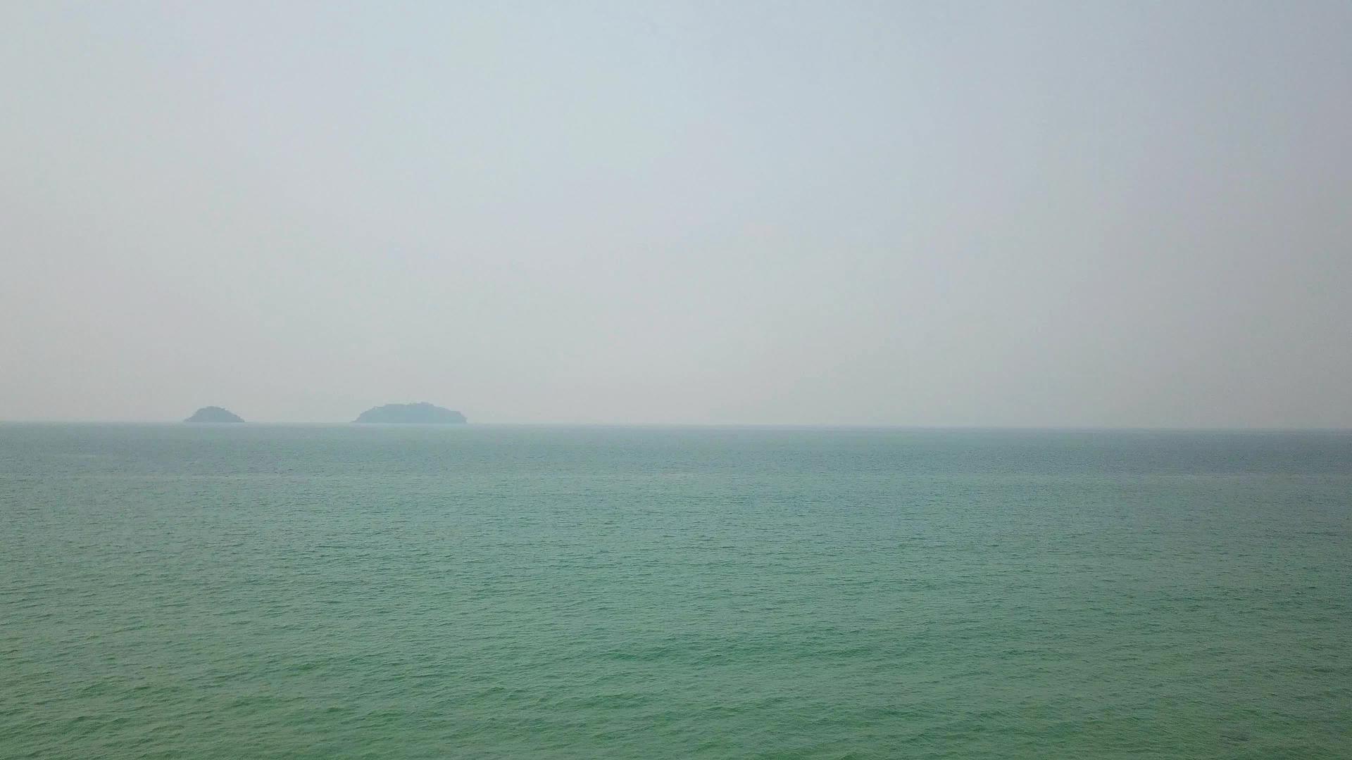 从远处可以看到泰国海上的烟雾岛上有一层白烟和小波浪视频的预览图