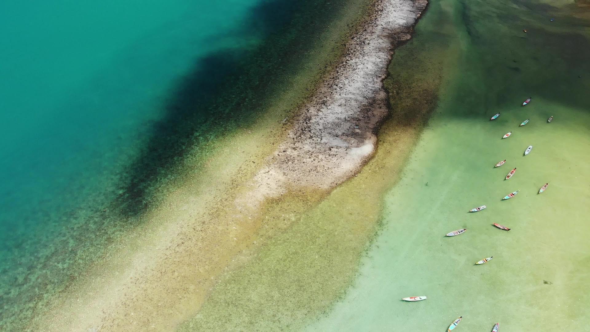 漂浮在蓝色海洋表面的小彩色木制渔船视频的预览图