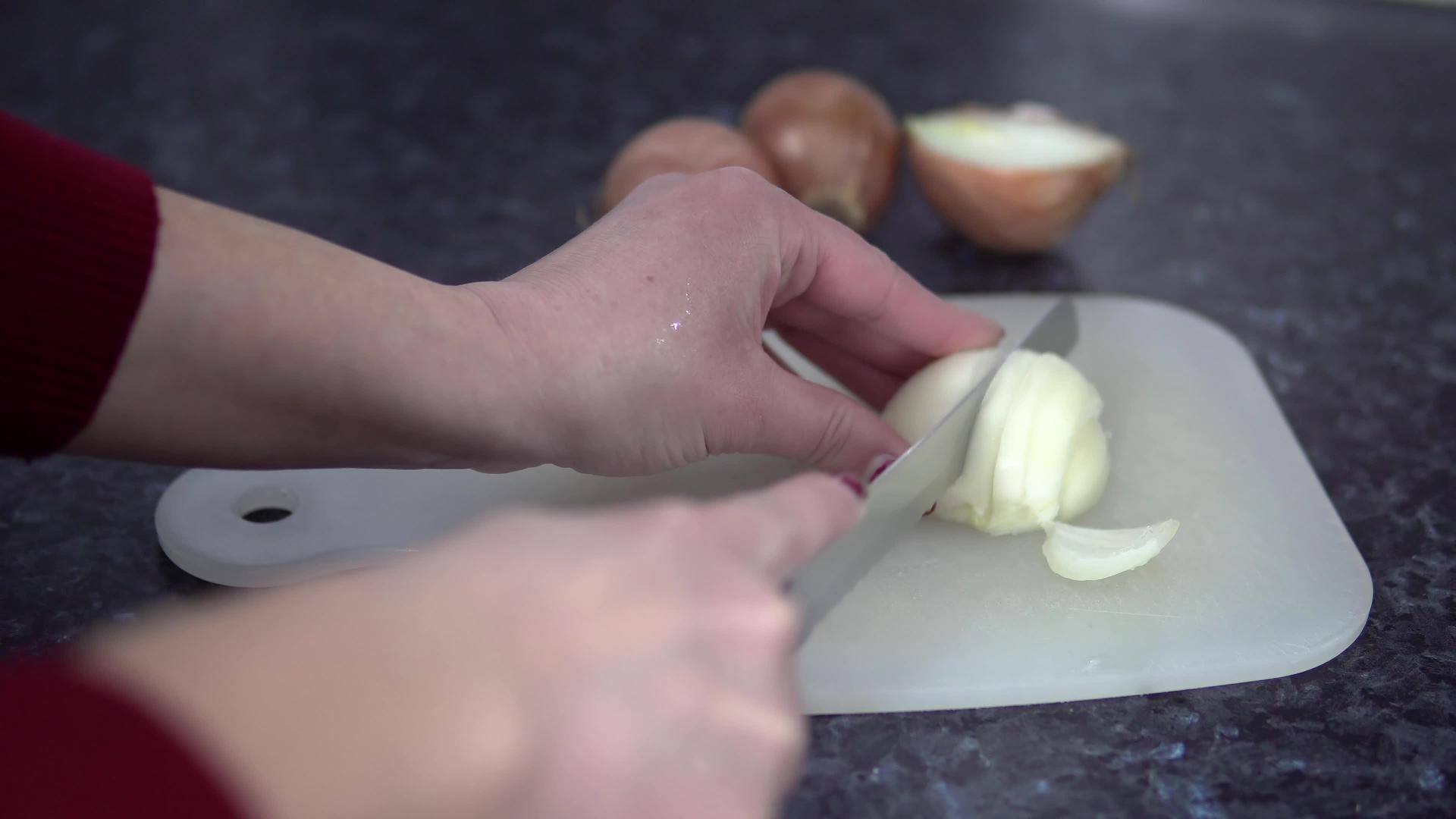 用锋利的刀在厨房板上切洋葱视频的预览图
