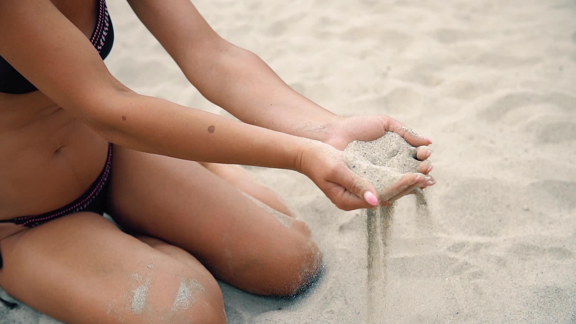女模手指之间的沙滩沙子倾斜视频的预览图