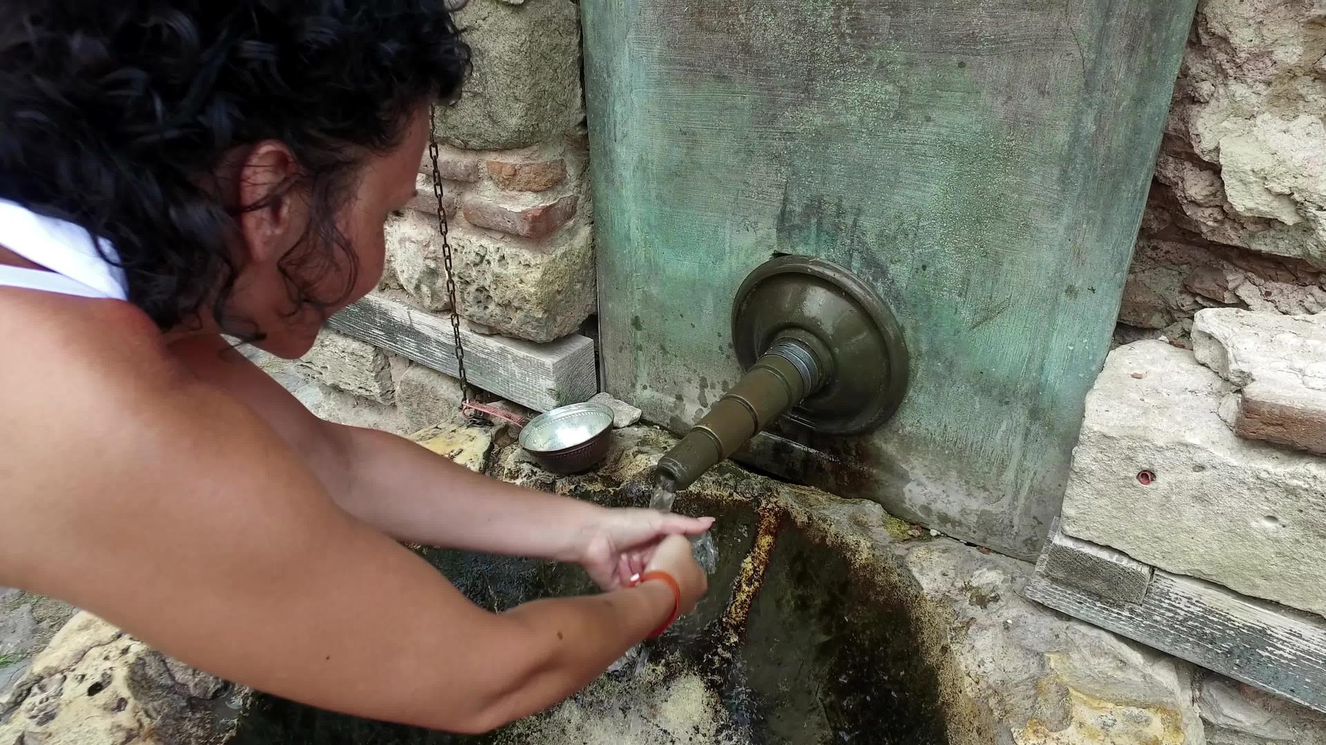 布加里河谷妇女用水洗手Nisebar的旧水龙头视频的预览图