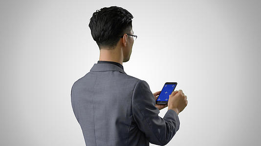 4k灰底抠像穿西装使用蓝幕手机背影形象视频的预览图