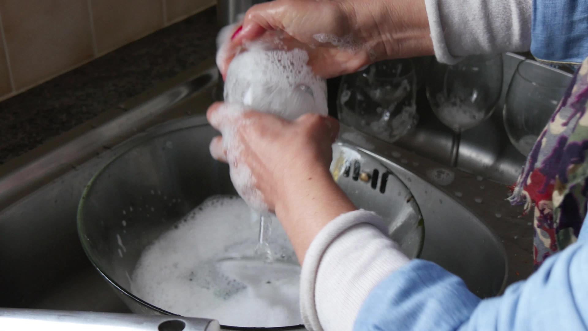 一个女人洗碗的手的特写视频的预览图