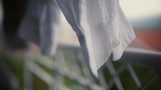 挂在户外的白色洗衣衬衫有选择性的电影聚焦视频的预览图