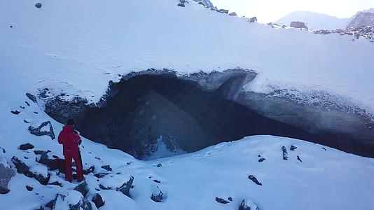 登山者看着冰洞的入口视频的预览图