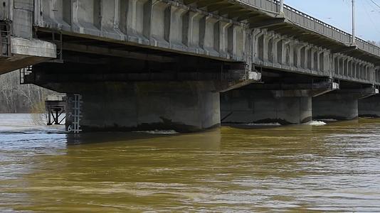 流经桥下的强大肮脏的水流视频的预览图