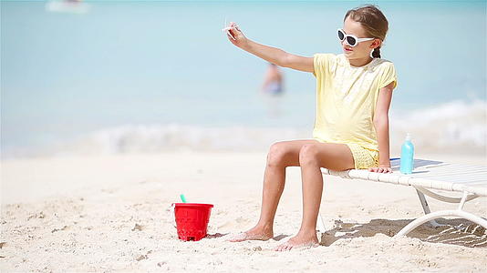 快乐的小女孩手里拿着玩具飞机孩子们在白色的海滩上视频的预览图