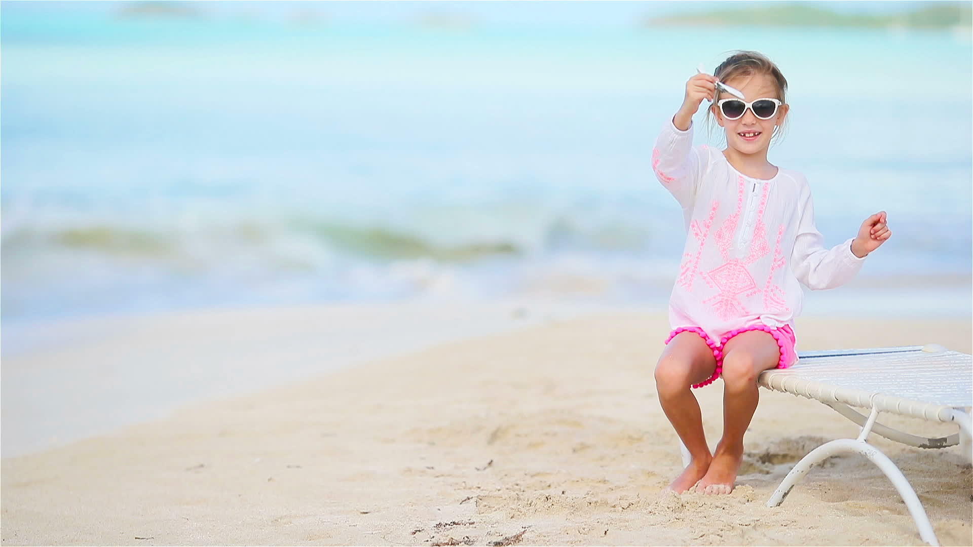 快乐的小女孩带着玩具飞机在白色的海滩上拿着玩具飞机视频的预览图