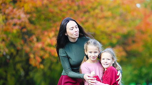 秋天的母亲和孩子的家庭年轻的母亲和小女孩享受温暖的秋天视频的预览图