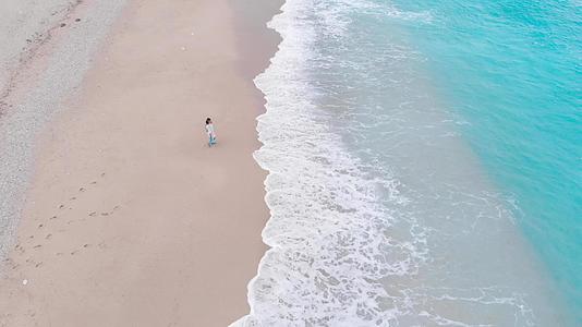 孤独的女人在海浪中漫步在热带海滩上视频的预览图