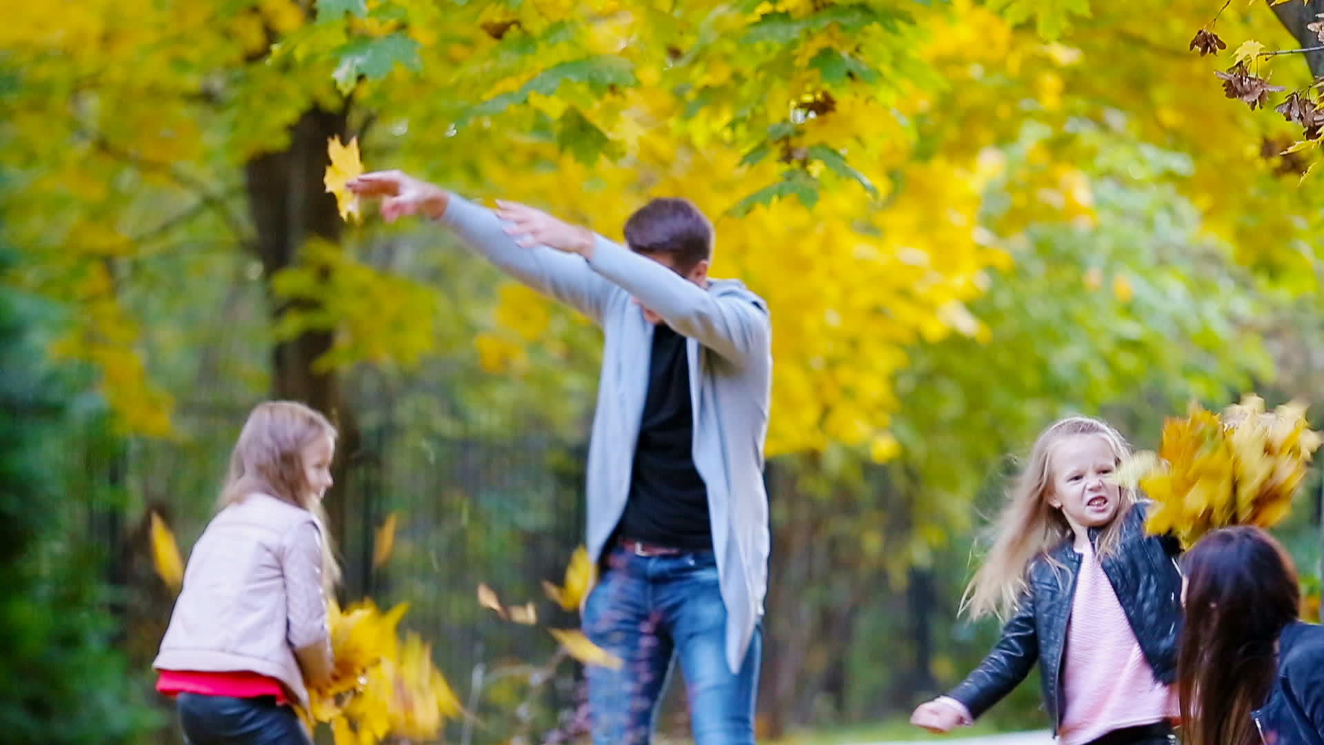 秋天年轻的家庭在户外玩得很开心秋天放树叶视频的预览图