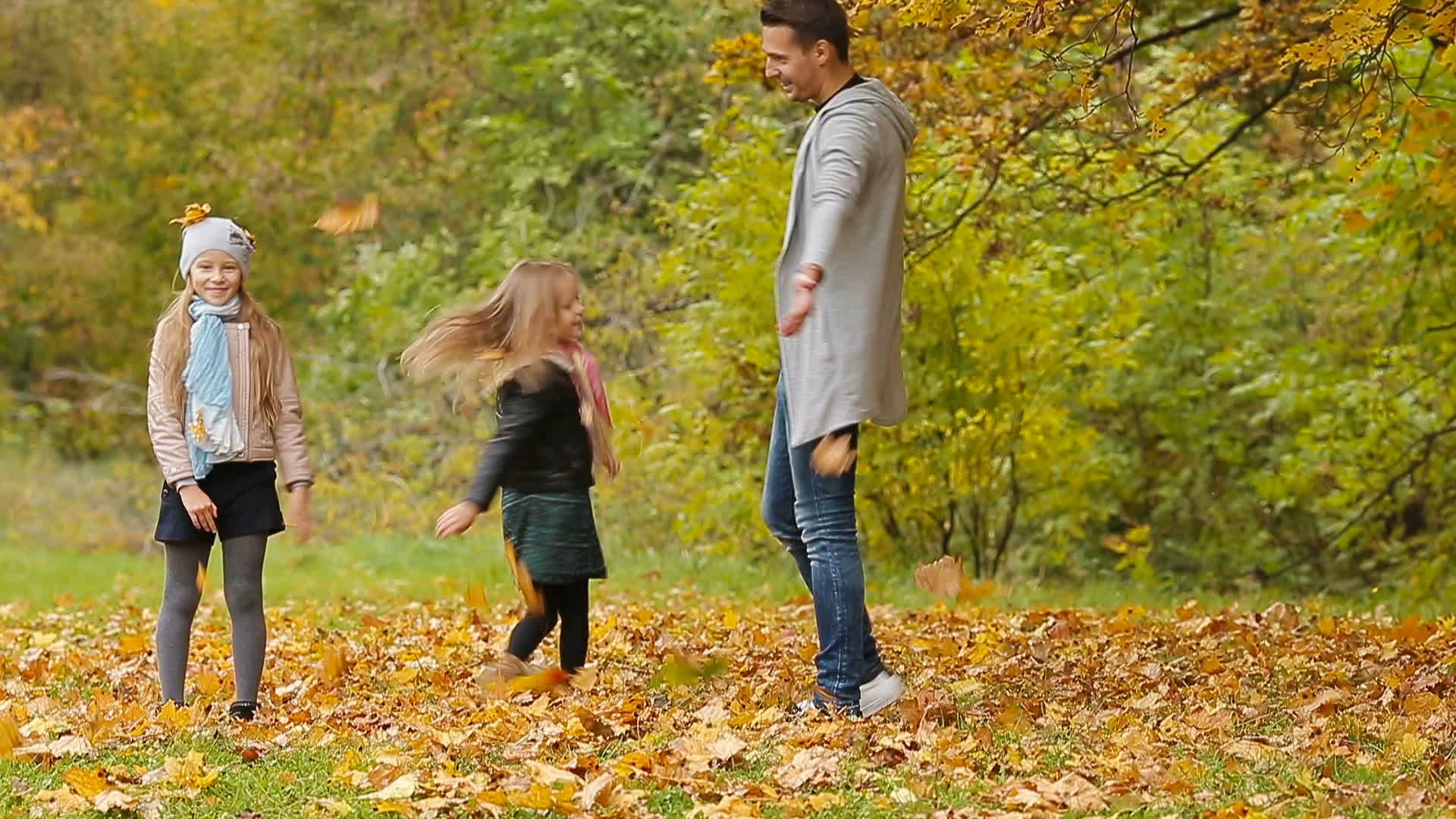 秋天年轻微笑的家庭在户外玩耍和扔树叶视频的预览图