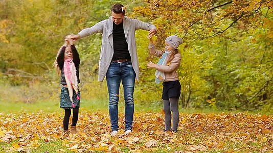 秋天当你在户外玩耍和扔树叶时家庭是幸福的视频的预览图
