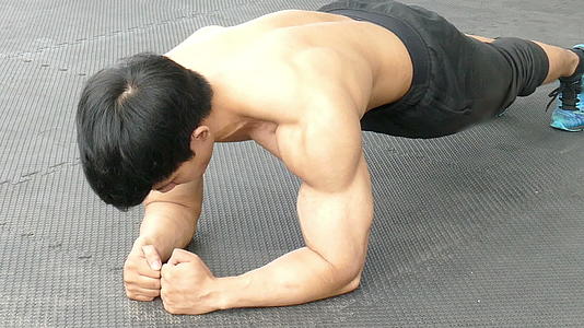 年轻的肌肉男在健身房做平板支撑在健身中心锻炼视频的预览图