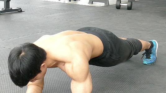 年轻的肌肉男在健身房做平板支撑在健身中心锻炼视频的预览图