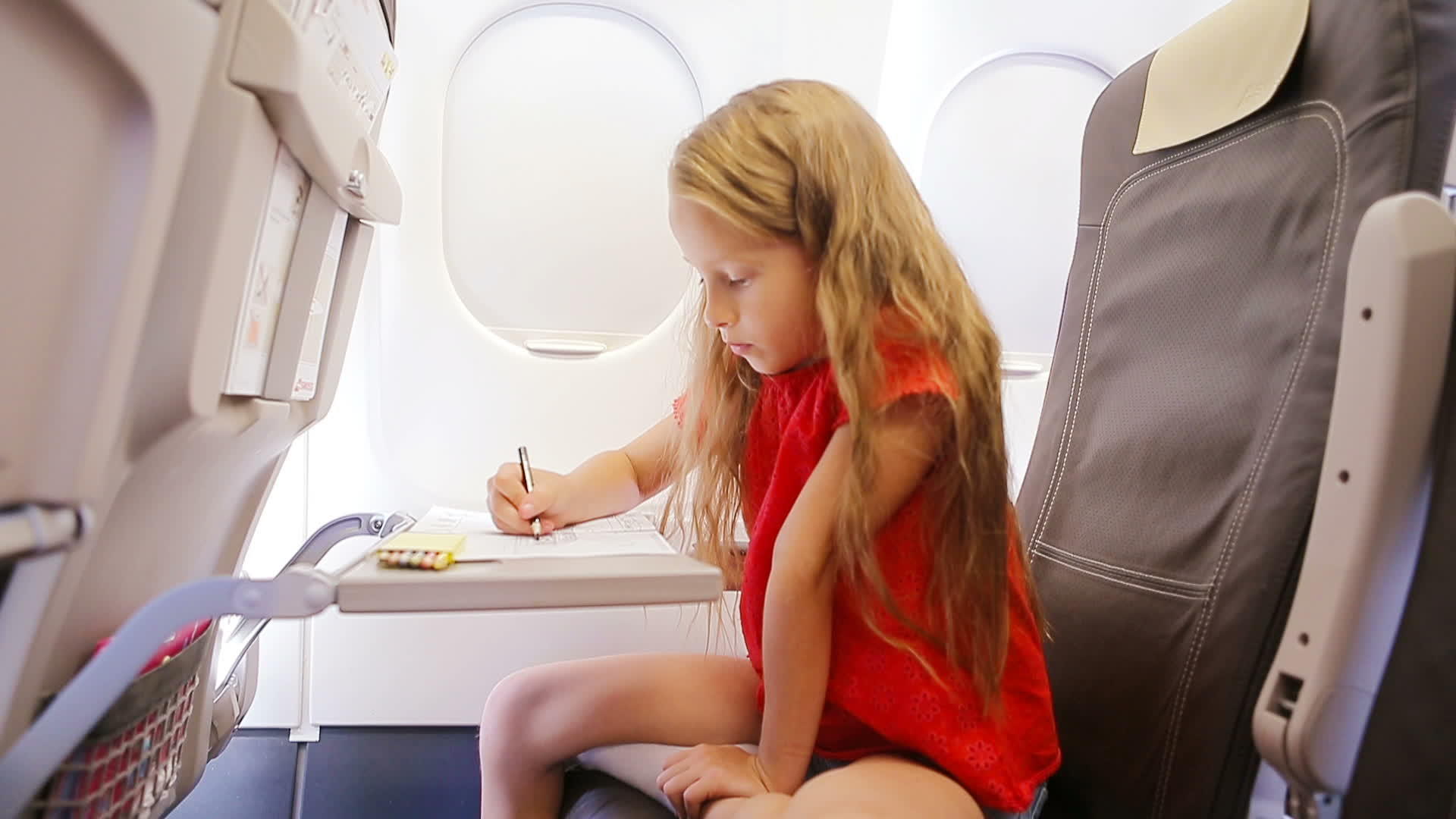 这个可爱的小女孩坐在飞机窗孩子们用彩色铅笔画画视频的预览图