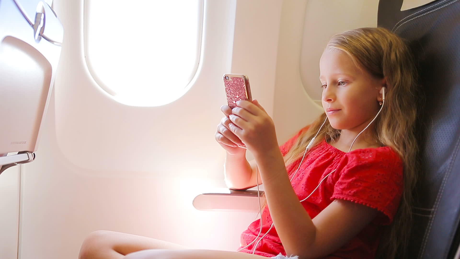 可爱的小女孩坐在窗前坐在飞机窗附近视频的预览图