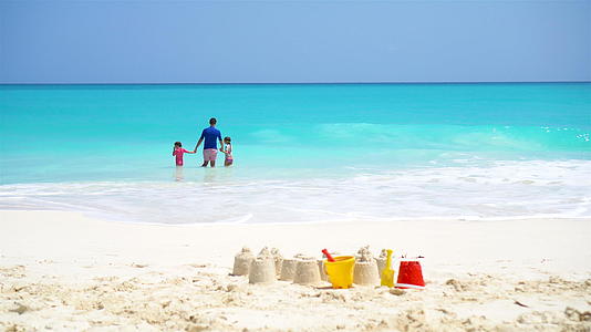 白色海滩上的沙堡包有塑料儿童玩具和家庭视频的预览图