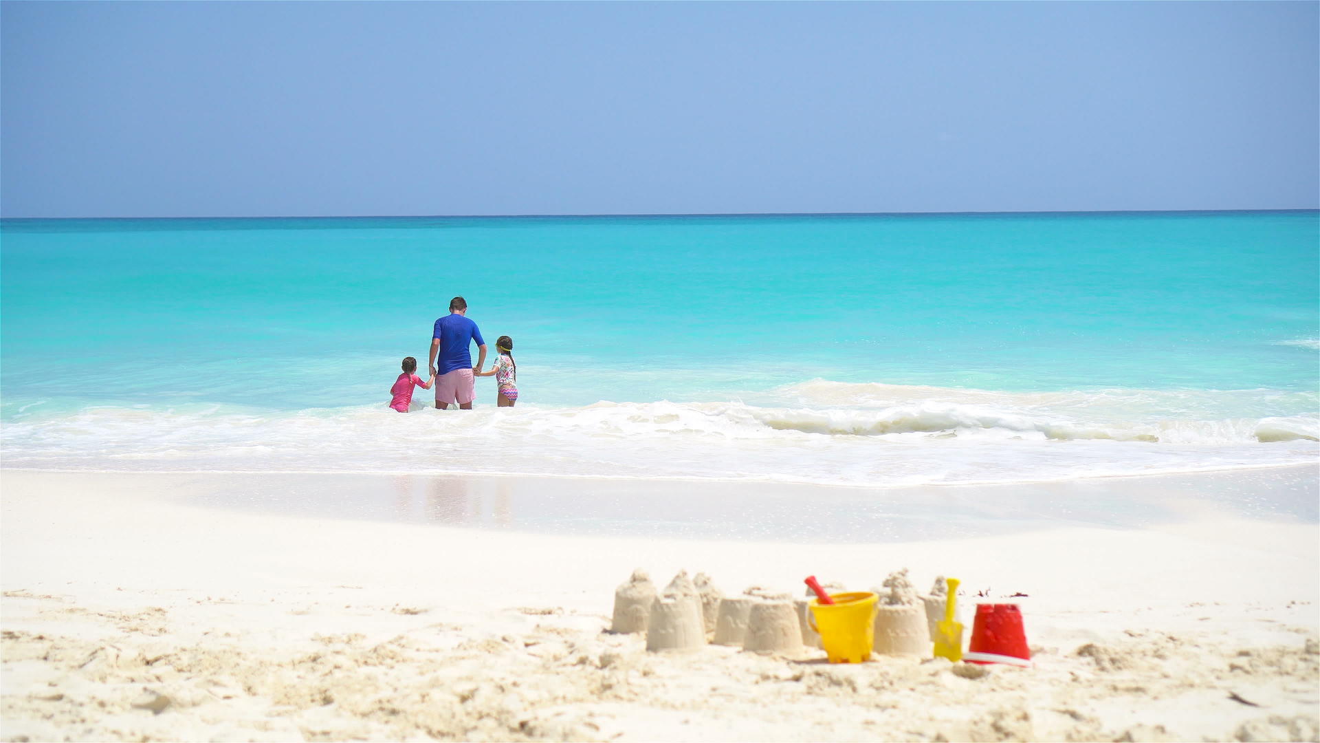 白色海滩上的沙堡包有塑料儿童玩具和家庭视频的预览图