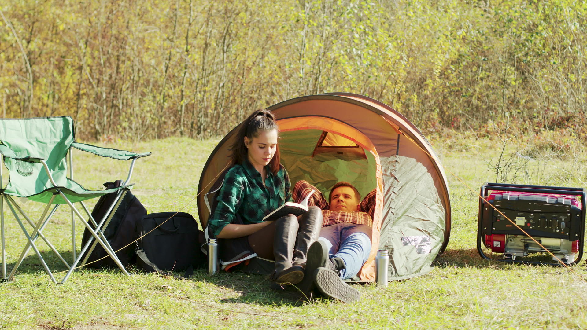 男朋友躺在露营帐篷上女朋友在看书视频的预览图