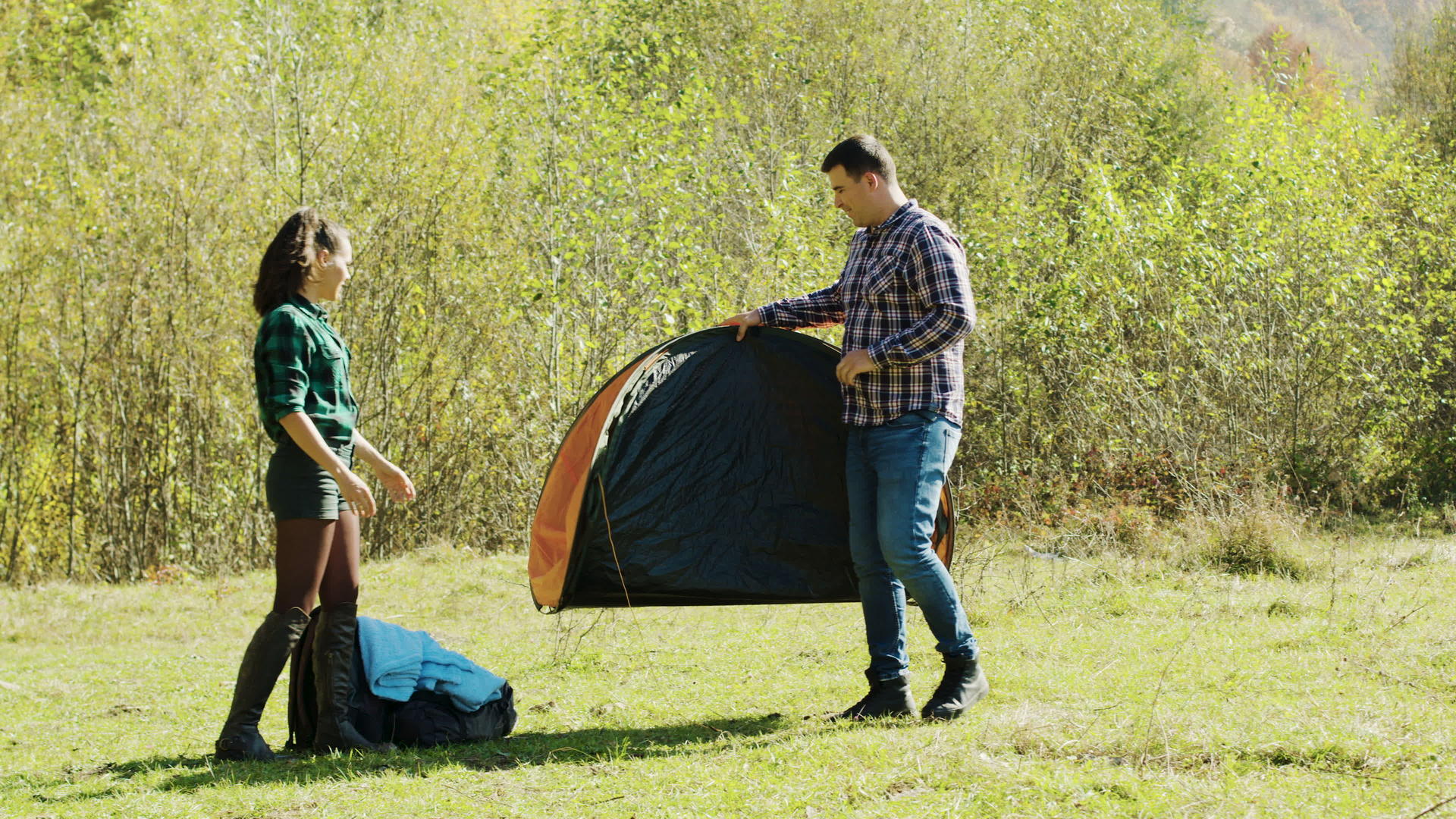 吸引人的年轻男子及其女友为露营搭建帐篷视频的预览图