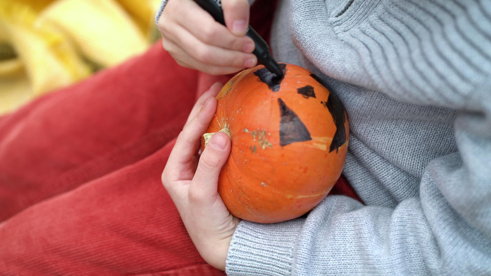 在秋天的森林里男孩画了橙色的南瓜和黑色的油漆视频的预览图