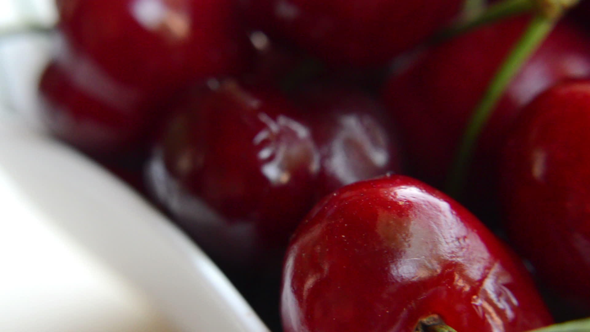 近距离拍摄成熟的红樱桃在白色背景上旋转视频的预览图