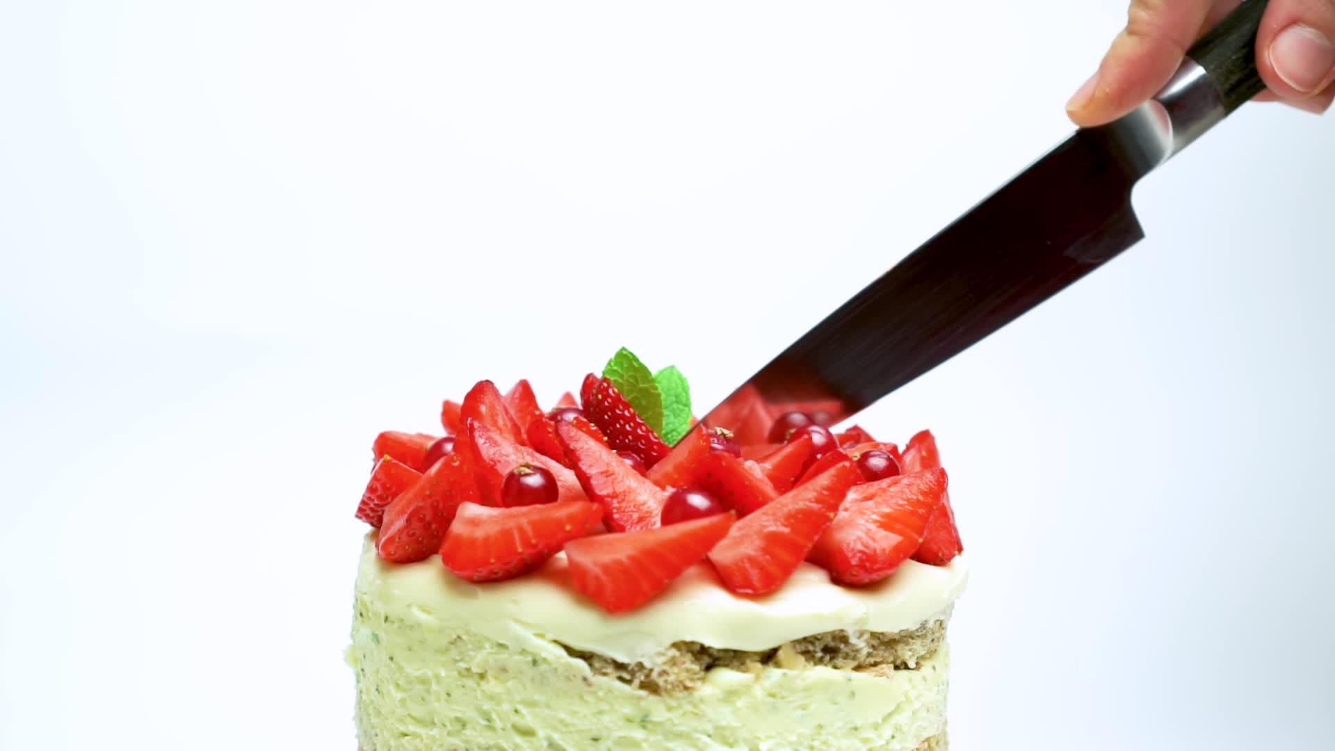 白人妇女用刀切了一个美味的蛋糕上面装饰着草莓和草莓视频的预览图