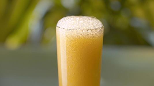 把冻黄橙汁倒进玻璃杯里视频的预览图