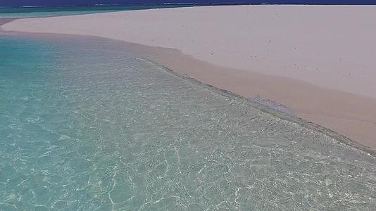 沿着蓝绿色海洋和阳光下浅沙背景的海滩之旅视频的预览图