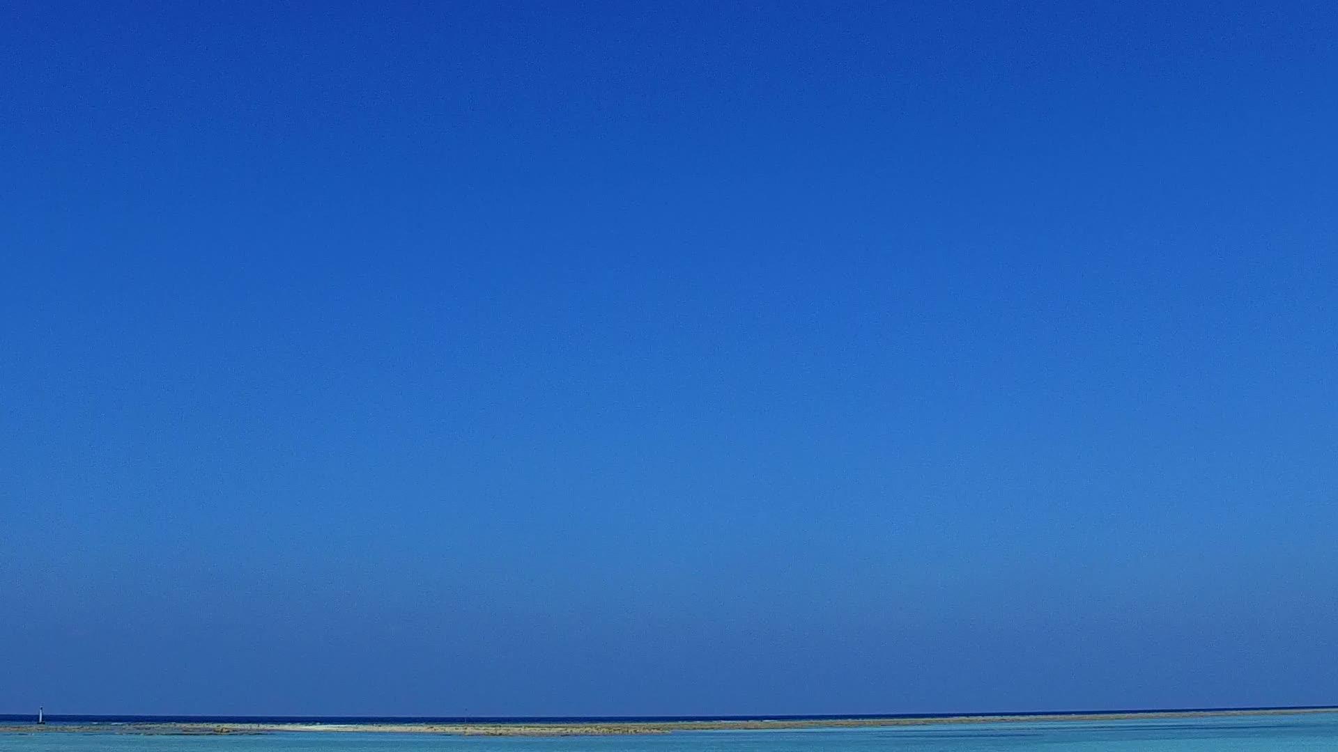 蓝海和白色沙滩在珊瑚礁附近的平坦海滩上航行视频的预览图