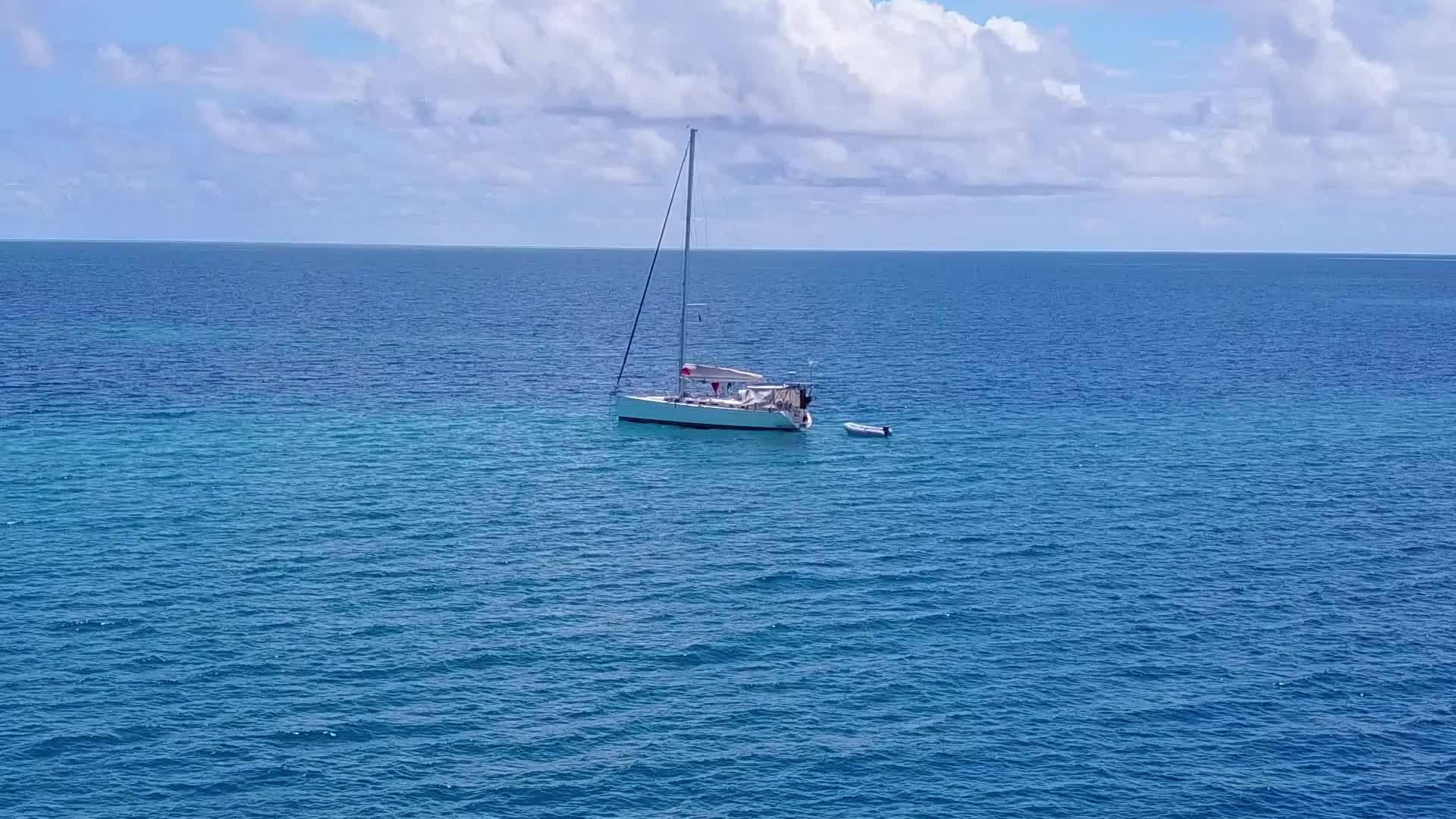 蓝海和白沙沿着蓝海和海滩附近的白沙背景航行视频的预览图
