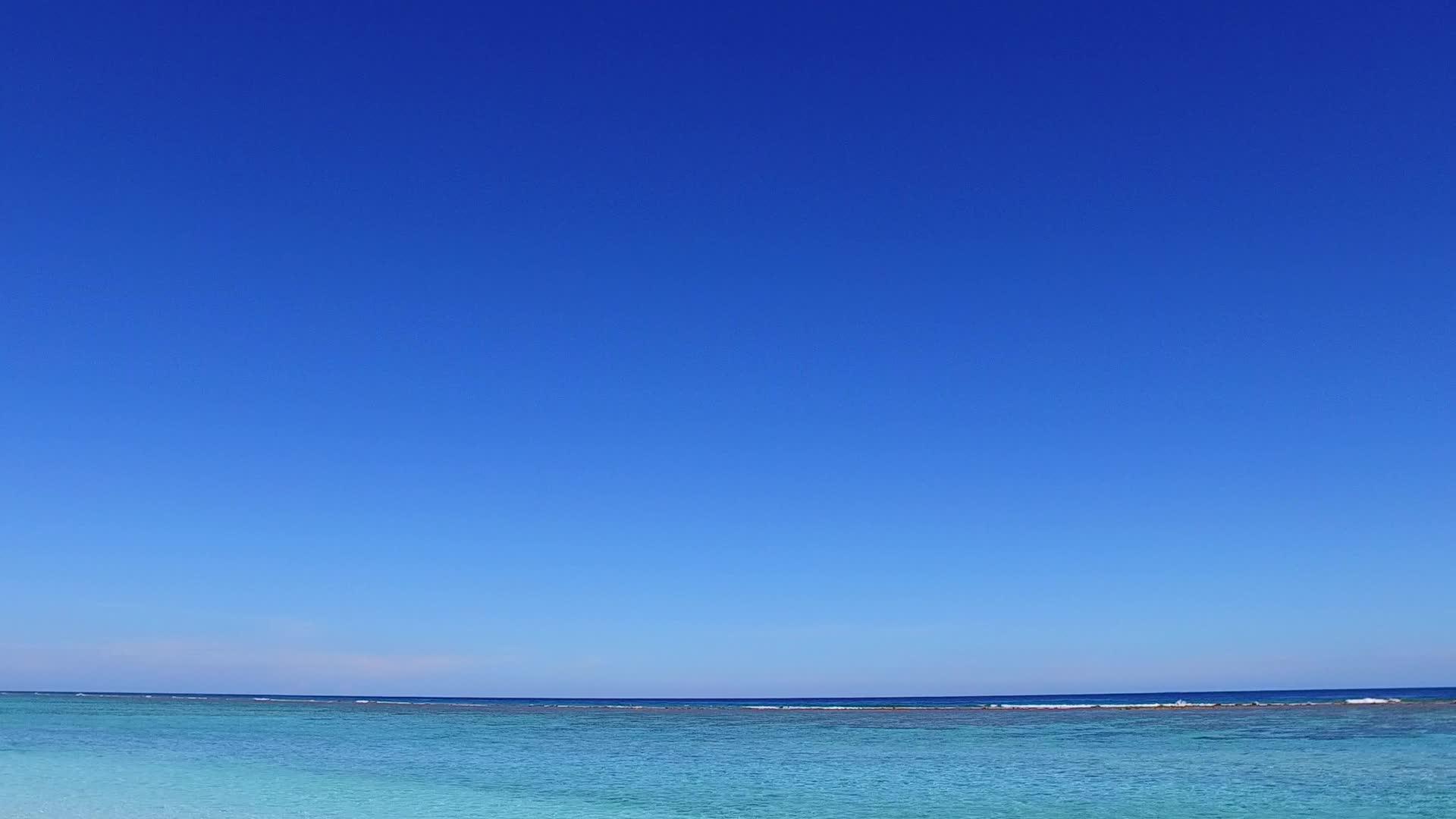 海洋和海滩附近的浅沙背景明亮的蓝色旅游海滩假日假日视频的预览图