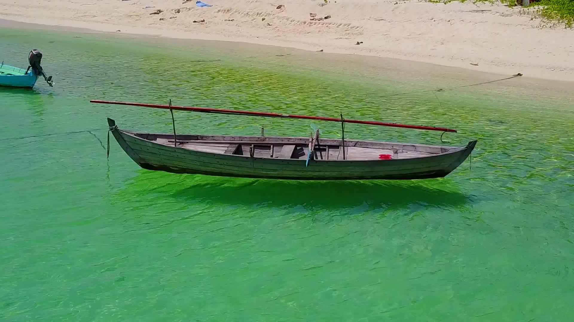 阳光明媚、宁静的环礁湖海滩在蓝绿色的水和阳光下清洁沙土背景视频的预览图