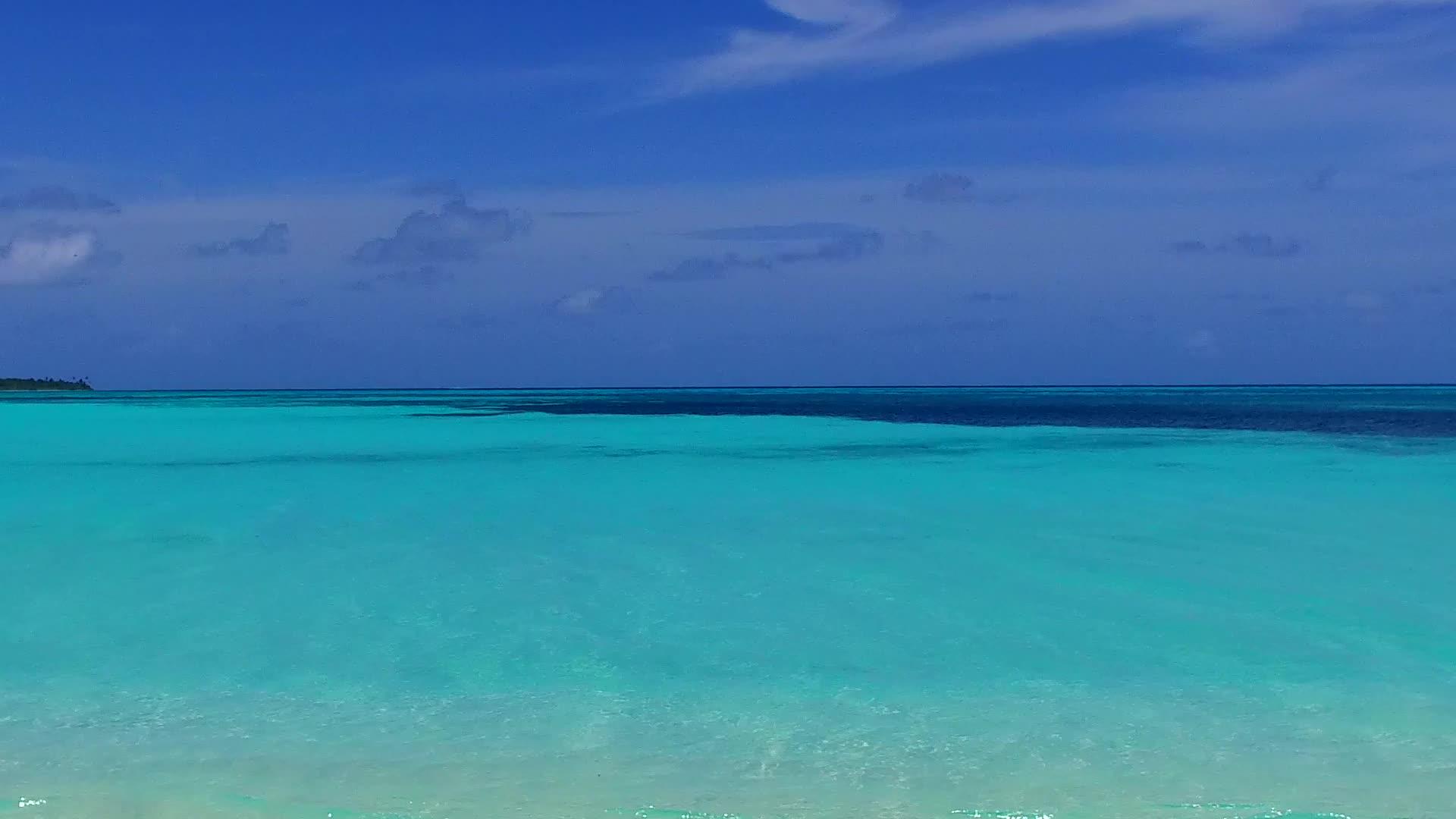 阳光明媚的海岸海滩上有清澈的环礁湖和白色的海面视频的预览图